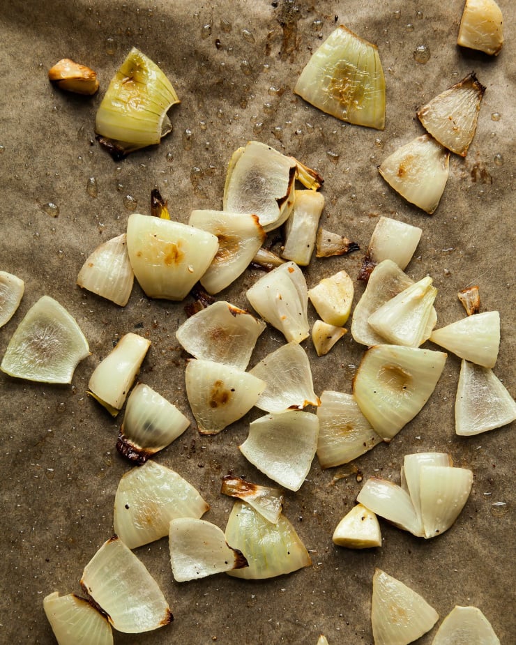 An overhead shot of roasted chopped onions on parchment paper.