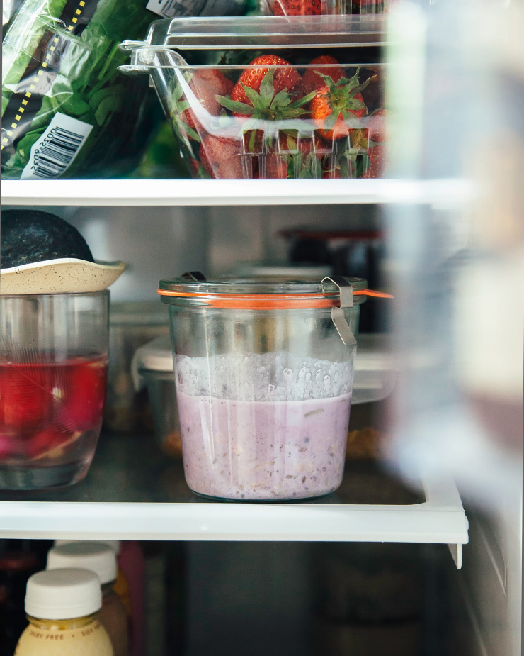 A jar of Bircher muesli is photographed inside of a fridge.