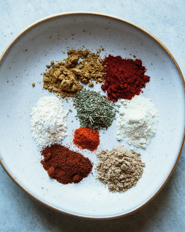 An overhead shot shows piles pf different spices in a shallow bowl.