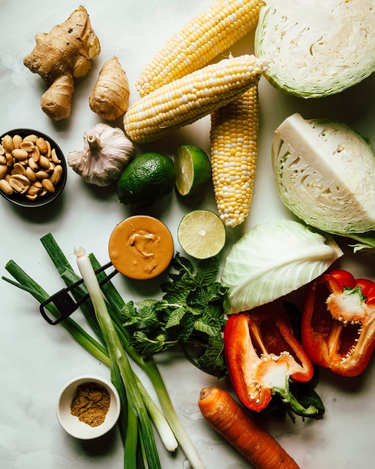 An overhead shot of slaw ingredients on top of a white painted background.