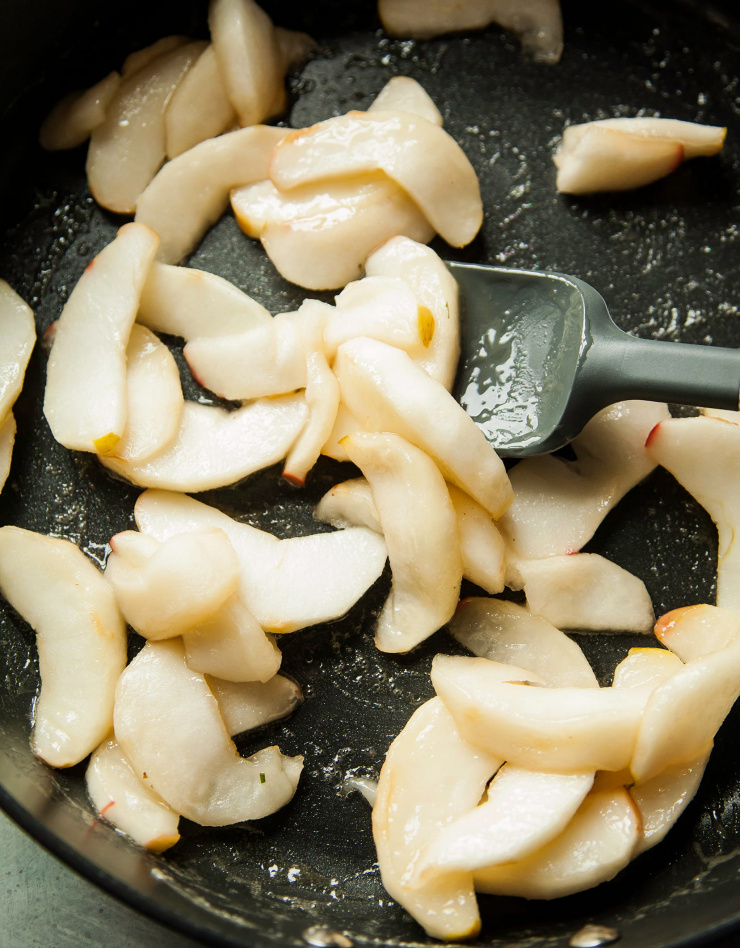 Image shows apple slices being sautéed. 