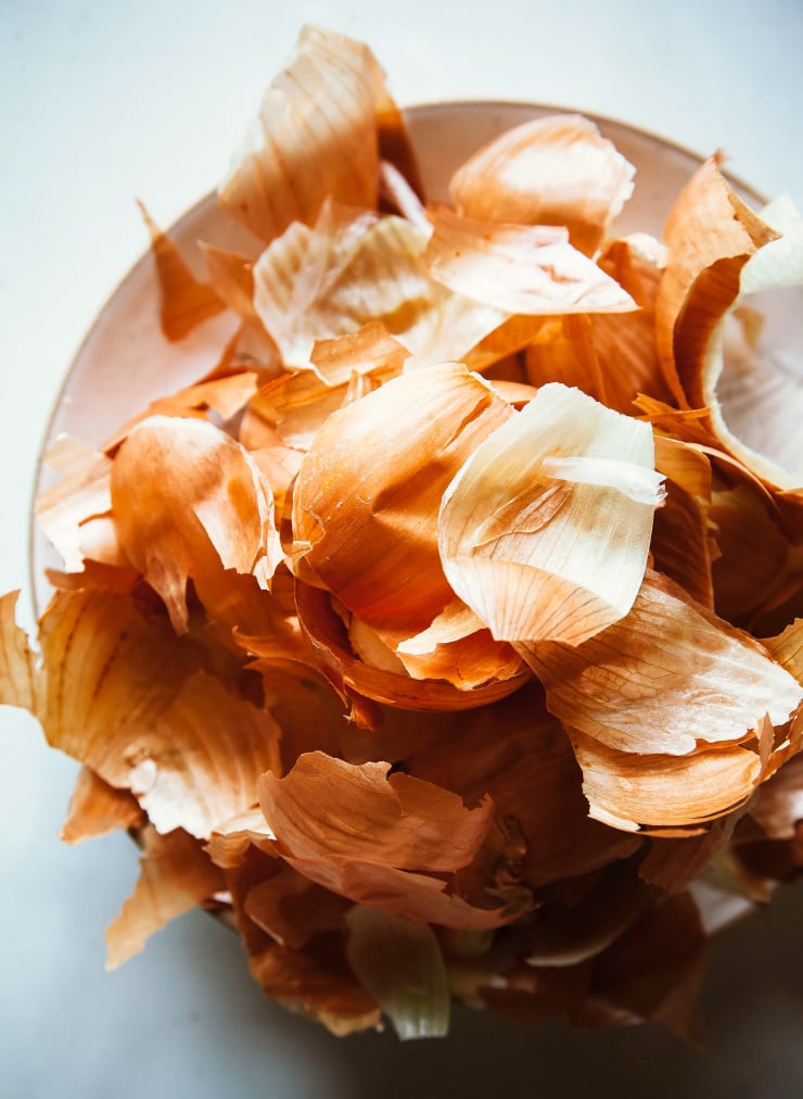An overhead shot of onion skins in a bowl.
