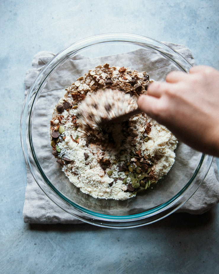 A hand is mixing together dry ingredients for baking.
