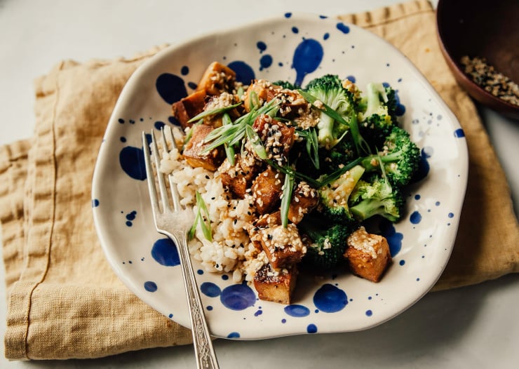Overhead shot of crispy sesame garlic tofu in a bowl with some brown rice and steamed broccoli