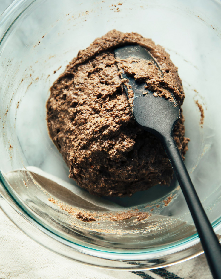 Close of shot of waffle batter being stirred in a clear glass bowl.