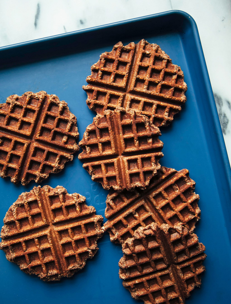 An overhead shot of cooked waffles on a royal blue baking sheet.
