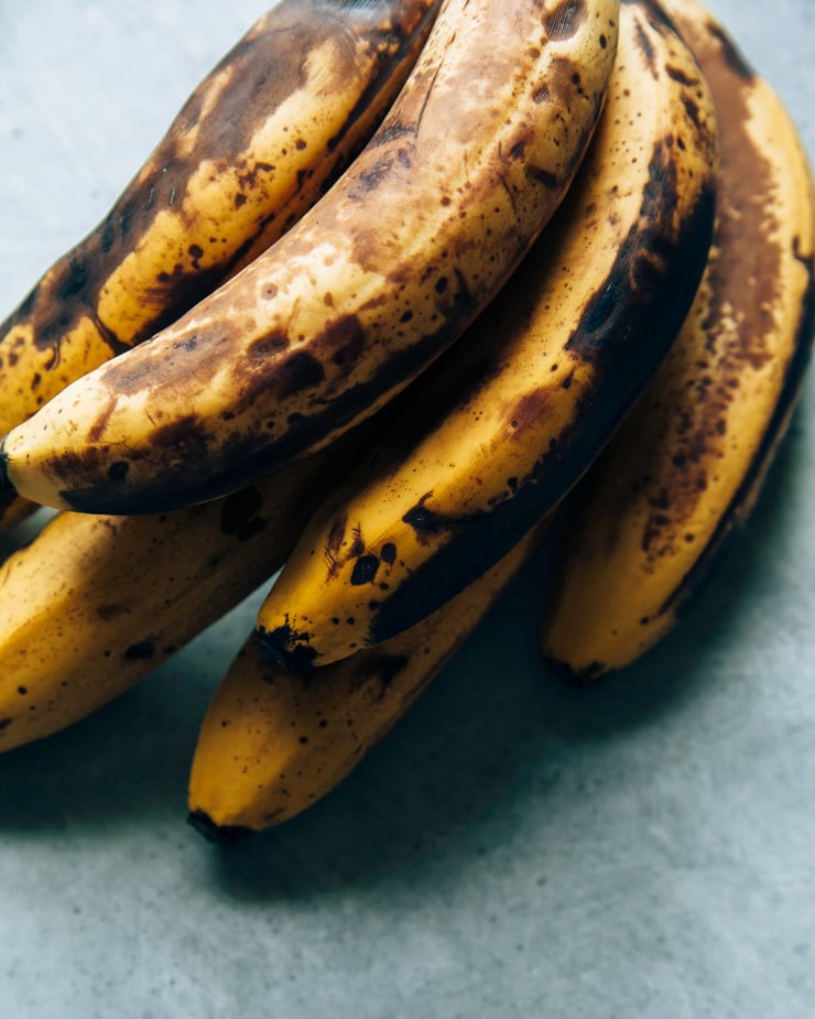 An overhead shot shows a bunch of ripe, spotty bananas.