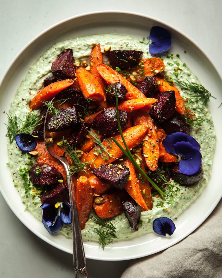 Overhead shot of grounding roasted roots with jalapeño yogurt sauce.