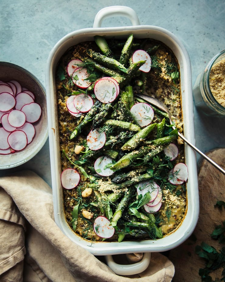 Overhead shot of pesto quinoa white bean bake in an enamelware tray.