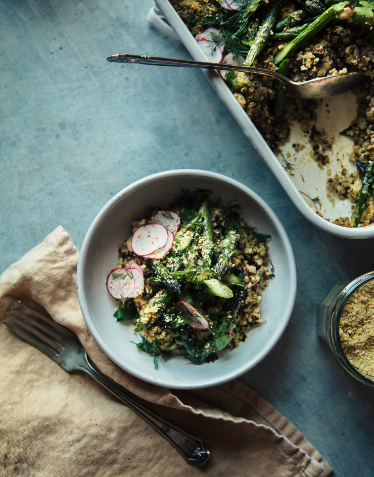 An individual serving of pesto quinoa white bean bake with roasted spring vegetables.