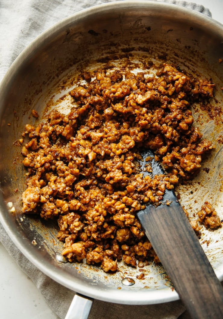 Sticky ginger tempeh getting sautรฉed in a pan.