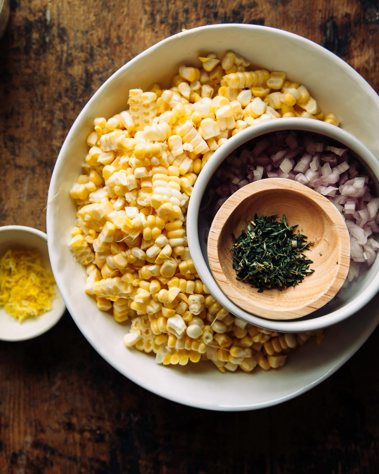 An overhead shot of prepped ingredients in bowls over a worn wooden background.