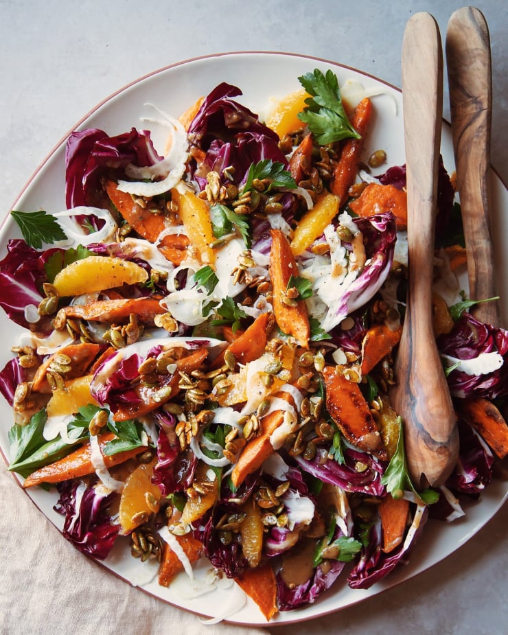 An overhead shot of a roasted sweet potato and radicchio salad with coriander candied pumpkin seeds, shaved fennel and orange.