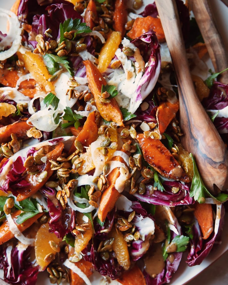 An up close, overhead shot of a roasted sweet potato and radicchio salad with coriander candied pumpkin seeds, shaved fennel and orange.