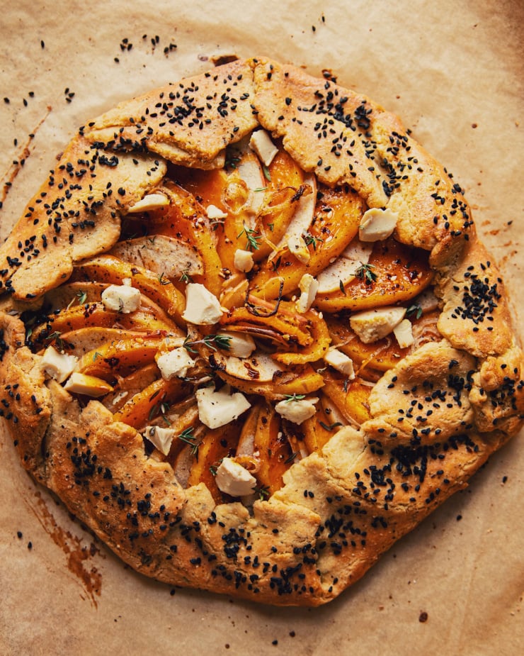 An overhead shot of a vegan butternut galette with apples, shallots, Dijon mustard, and gluten-free black pepper crust.