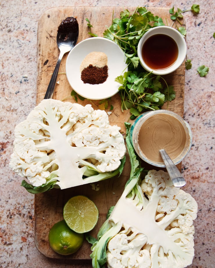 Overhead shot of ingredients on a cutting board over top of a pink stone-like background.