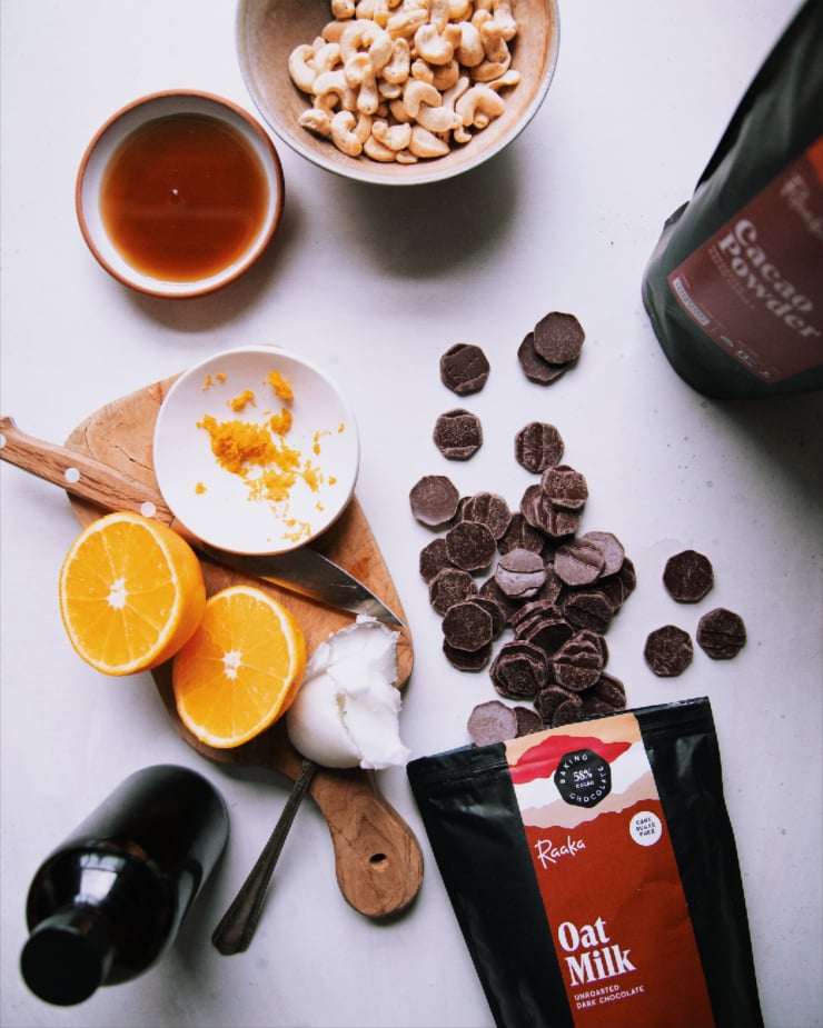 An overhead shot of ingredients for a vegan cheesecake on a white background.