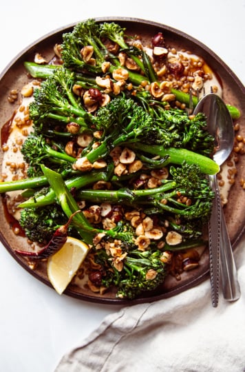 An overhead shot of a broccolini dish on a brown plate.