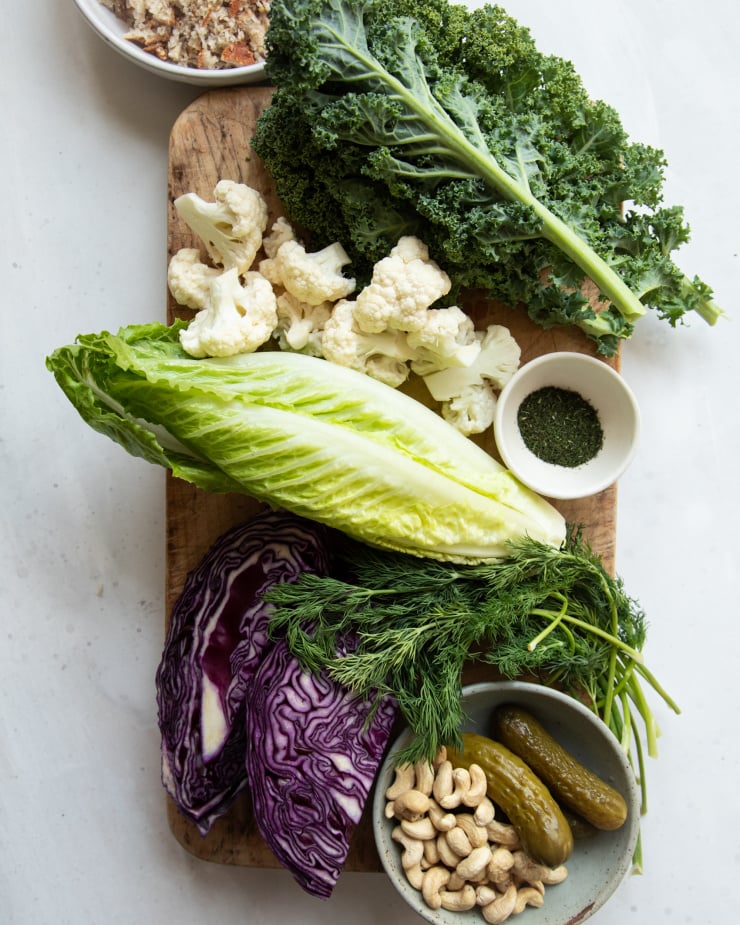 Overhead shot of ingredients for a dill pickle salad, on top of a worn cutting board.