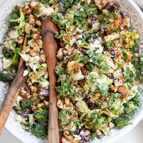 An overhead shot of a colourful chopped salad with creamy dressing.