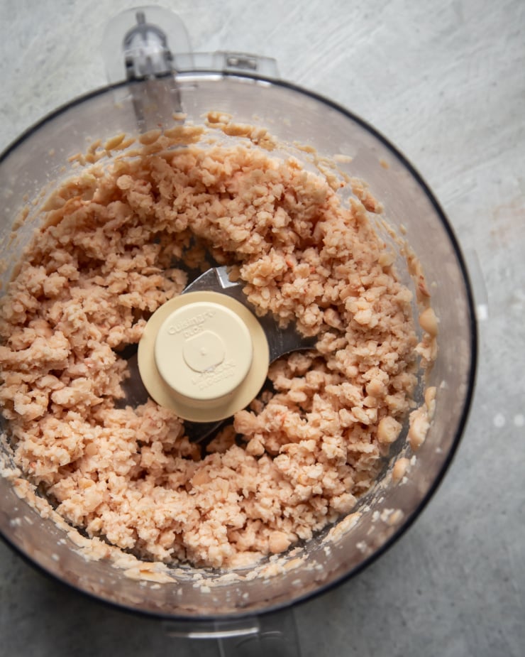 An overhead shot of white beans that have been ground up in a food processor.