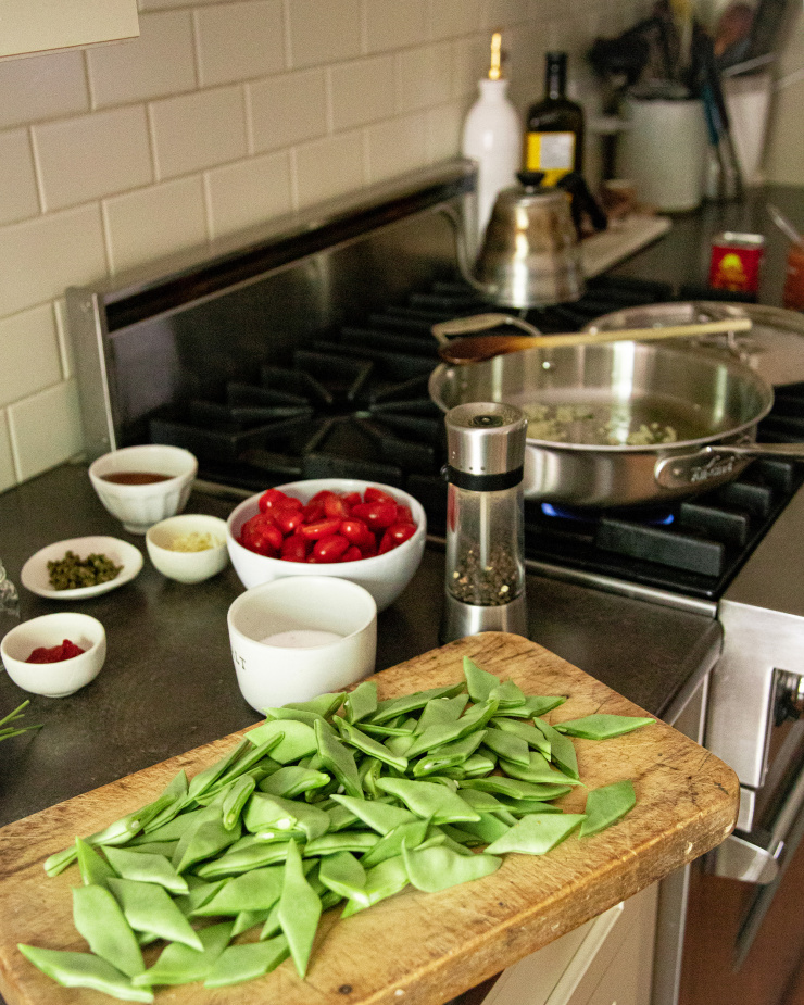 A kitchen scene featuring a gas stove and prepped ingredients on a nearby counter.