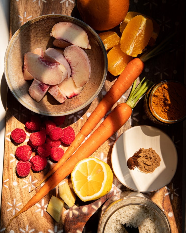 An overhead shot of ingredients for a golden peach sunrise smoothie, shot in harsh light.