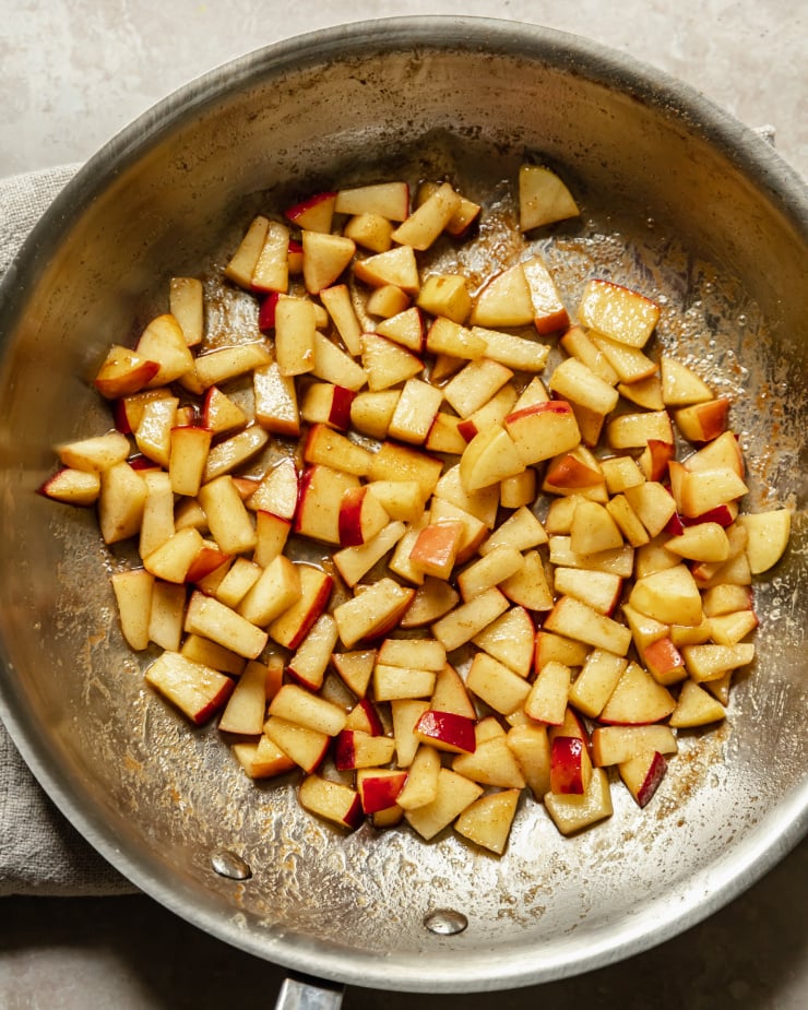 An overhead shot shows diced apples sautéing in a skillet.