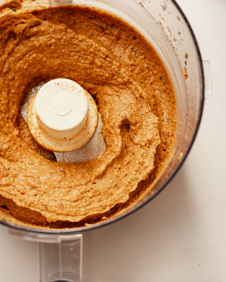 An overhead shot of a deep red black bean dip that has just been mixed up in a food processor.