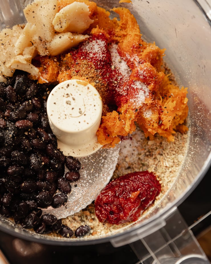 An overhead image of ingredients for a black bean dip in a food processor, pre-blending.