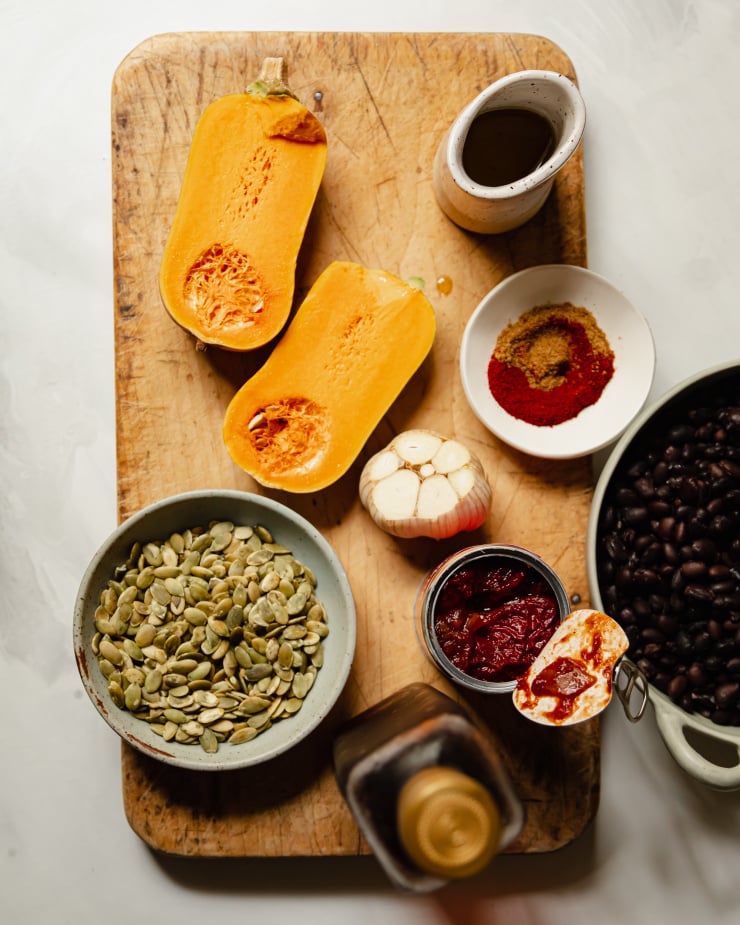 An overhead shot of ingredients used in a black bean dip with roasted squash and garlic.