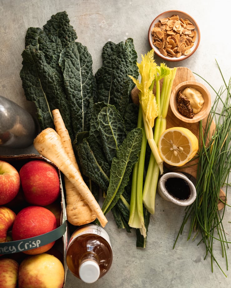 An overhead shot of ingredients for a vegetable side dish on top of a grey-blue speckled background..