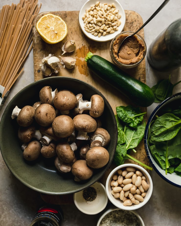 An overhead shot of ingredients for a vegan pasta dish with mushrooms.