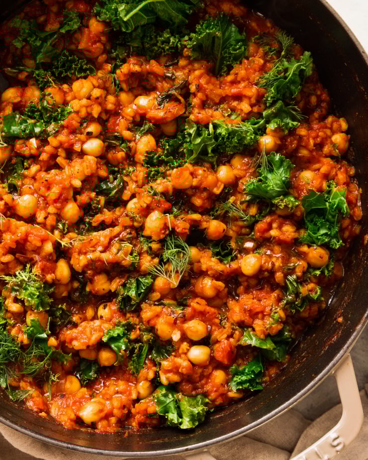 An up close, overhead shot of a farro chickpea skillet with tomatoes and kale.
