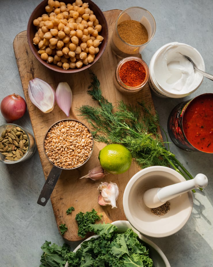 An overhead shot of ingredients used for a farro chickpea skillet dinner with kale and spices.