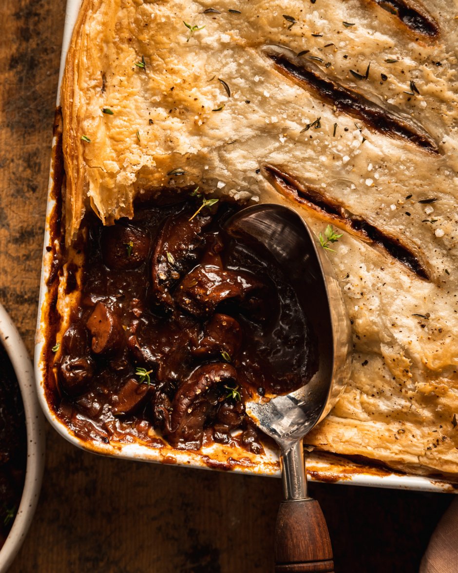 An up close shot of a vegan mushroom bourguignon pot pie being scooped and served.