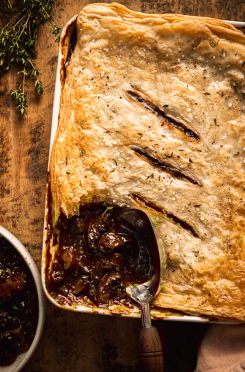 An overhead shot of a vegan mushroom bourguignon pot pie being scooped and served.