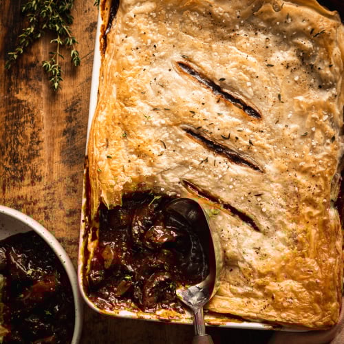 An overhead shot of a vegan mushroom bourguignon pot pie being scooped and served.