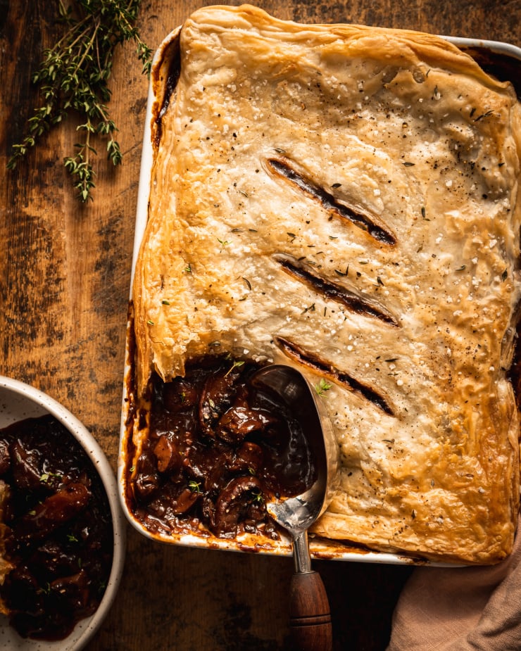 An overhead shot of a vegan mushroom bourguignon pot pie being scooped and served.