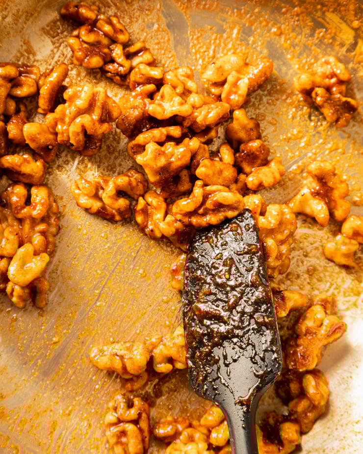 An overhead shot of walnuts being candied in a sauté pan.