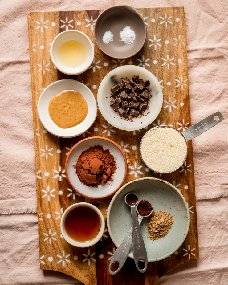 An overhead shot of portioned and measured ingredients in small bowls/spoons for a cookie recipe.