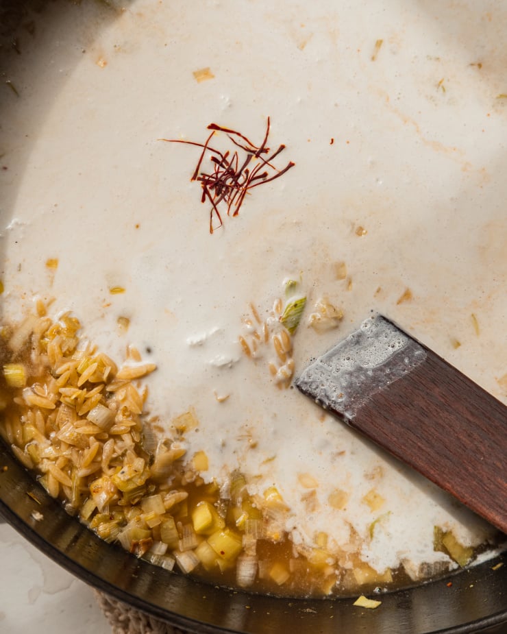 An overhead image of saffron threads sitting on top of some non-dairy cream in a pot.