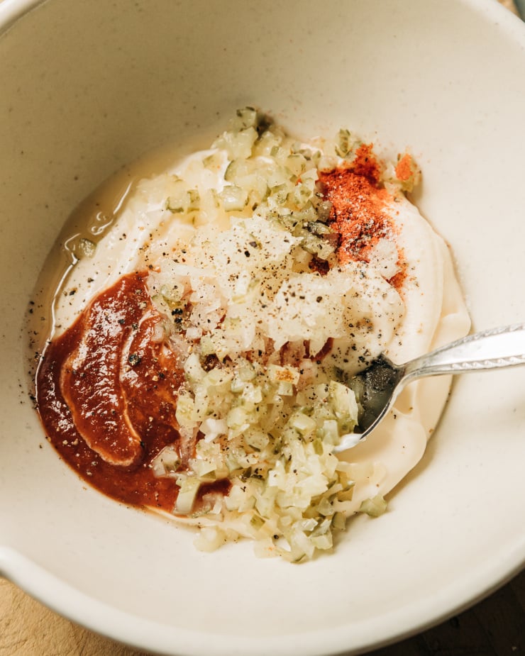 An up close overhead shot of ingredients for a vegan thousand island-style dressing in a bowl, before being stirred together.