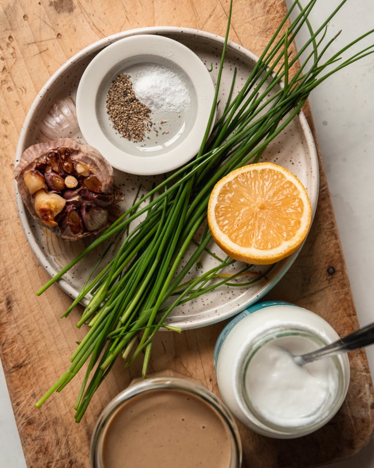 An overhead shot of ingredients used for a vegan roasted garlic chive yogurt sauce.