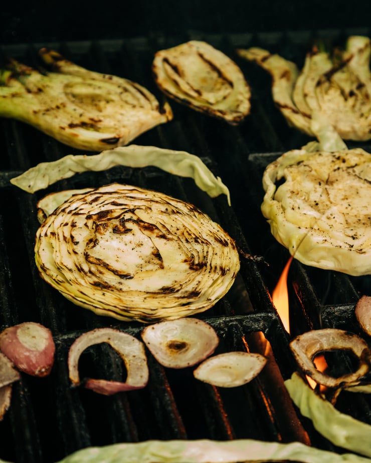 A 3/4 angle shot shows rounds of cabbage, fennel, and red onion on the grill.