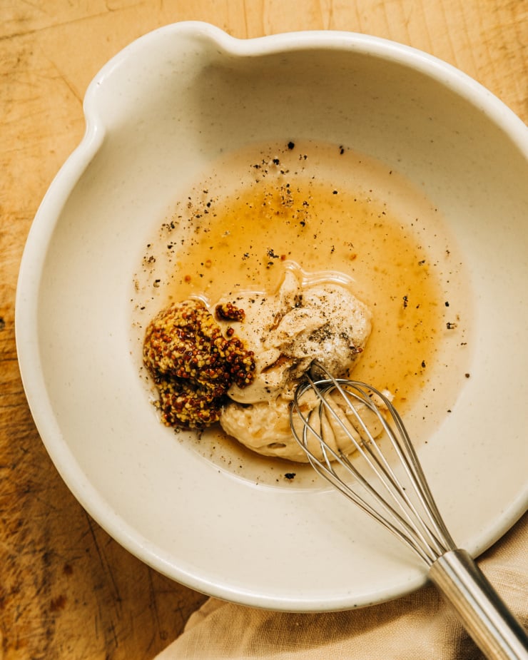 Overhead image shows ingredients for a vegan maple mustard cream in an off white bowl.