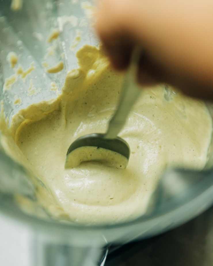 An overhead image shows a spoon stirring up some creamy dip in the jar of a blender.