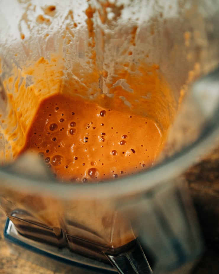 A slight 3/4 angle shows a blended up sun dried tomato "cream" in a blender pitcher.