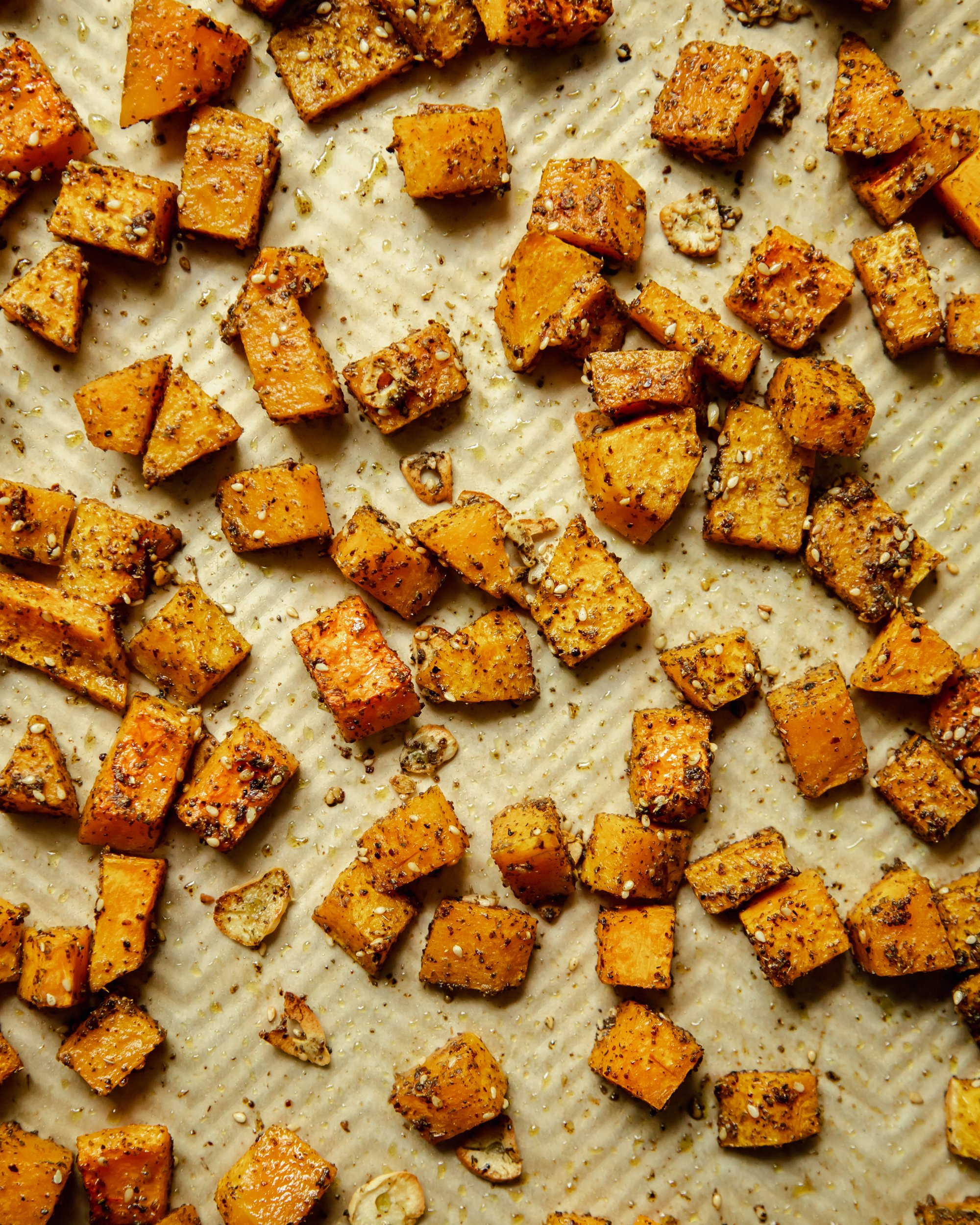 An overhead shot of roasted butternut squash that is absolutely covered in za'atar.