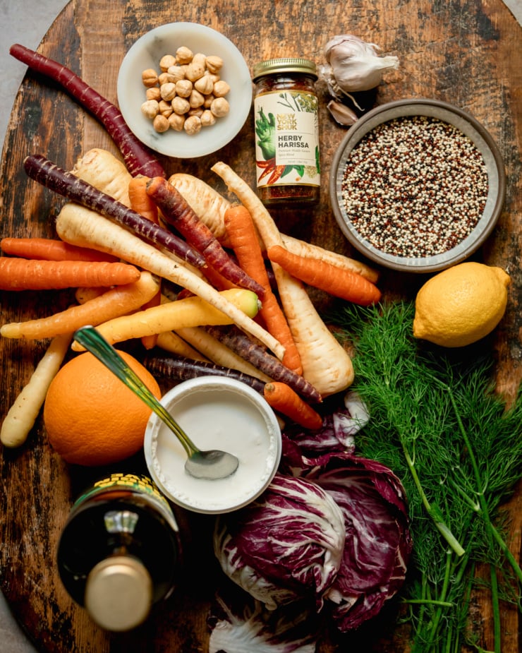 An overhead shot of ingredients used in a harissa carrot and parsnip salad with quinoa and vegan yogurt sauce.